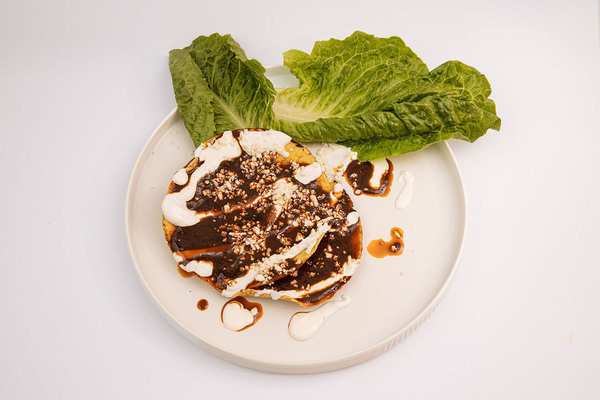Tostadas Topped with Cream, Cheese, Lettuce, and Mole Amá